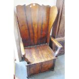 A 20TH CENTURY STANED OAK AND ELM LAMBING CHAIR, with shaped back and wing sides, solid seat over