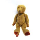 AN ENGLISH GOLD MOHAIR TEDDY BEAR circa 1930, with remains of a black vertically stitched nose, on a