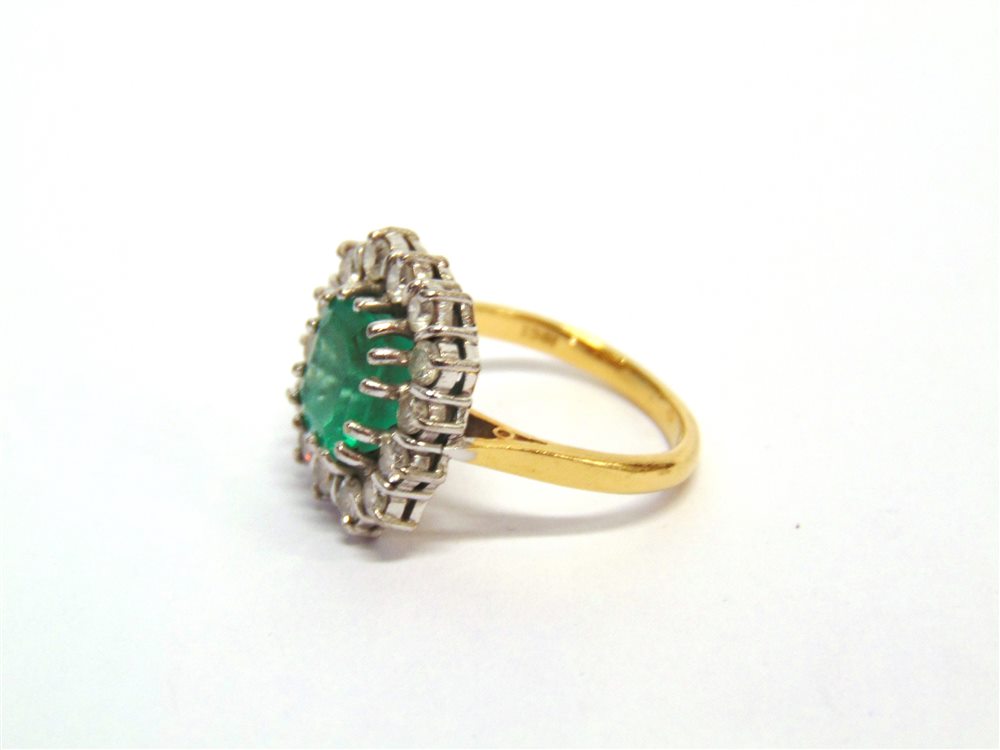 AN EMERALD AND DIAMOND CLUSTER RING stamped '18ct', the rectangular step cut stone, approximately - Image 2 of 2