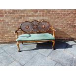 A CARVED WALNUT BERGERE SOFA with serpentine front upholstered seat on carved cabriole supports with