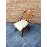 A WILLIAM IV/EARLY VICTORIAN ROSEWOOD NURSING CHAIR on acanthus carved front supports and four brass