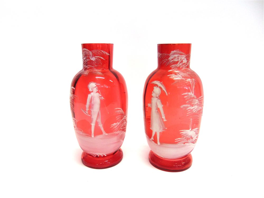 A PAIR OF CRANBERRY GLASS VASES with Mary Gregory enamelled decoration of a young boy and girl, 22.