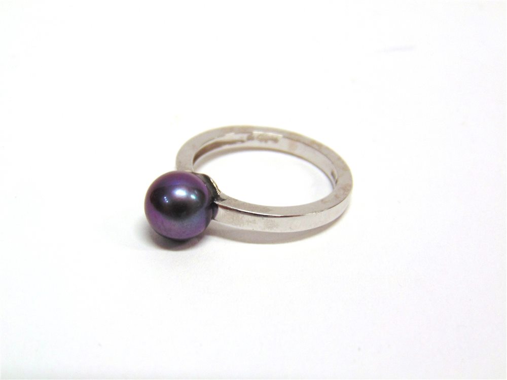 A SINGLE STONE BLACK CULTURED PEARL RING the white mount stamped '750', the pearl (untested and