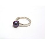 A SINGLE STONE BLACK CULTURED PEARL RING the white mount stamped '750', the pearl (untested and