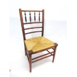 A STAINED BEECH RUSH SEATED CHILDS CHAIR with turned spindle back, 65cm high