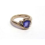 A TANZANITE AND DIAMOND THREE STONE 18 CARAT WHITE GOLD RING the oval cut flanked each side by