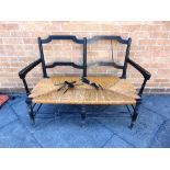 A WILLIAM MORRIS 'ROSETTI' RUSH SEAT SOFA, with ebonised beech frame on turned stretcher base, 119cm