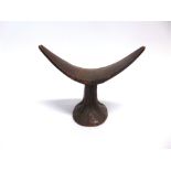 AN AFRICAN TRIBAL HEADREST with incised decoration, 21cm high, 26.5cm wide; together with three