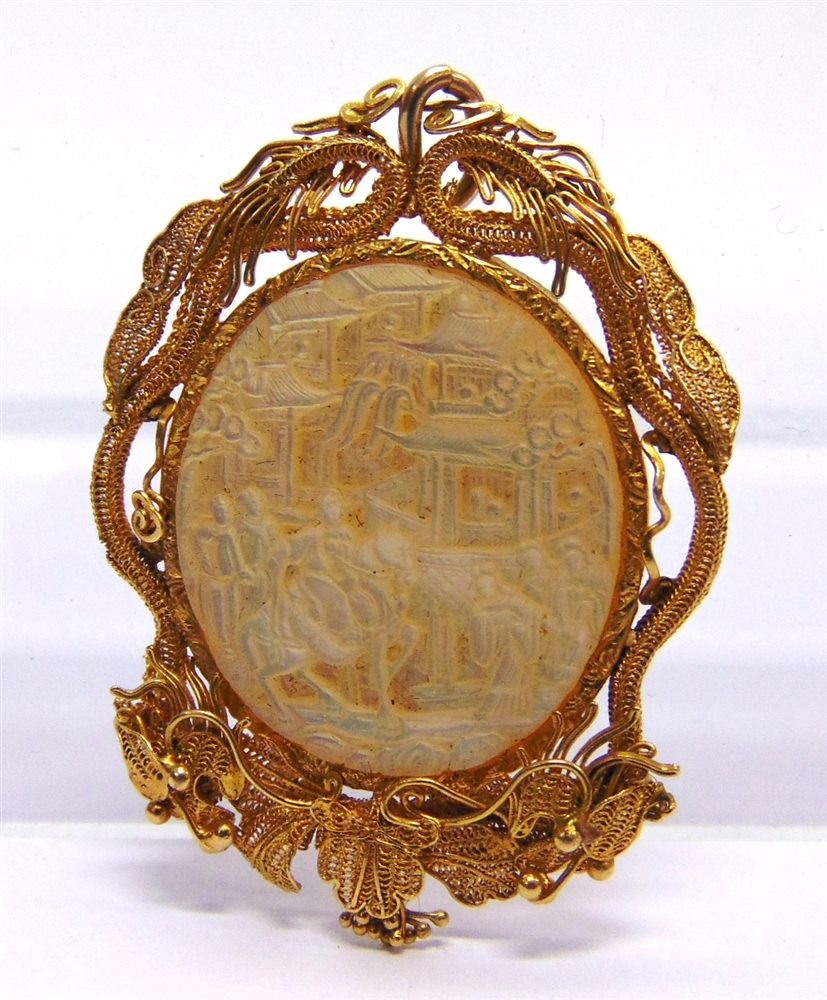 A CHINESE MOTHER OF PEARL MOUNTED PENDANT the oval panel within an unmarked gold coloured filigree