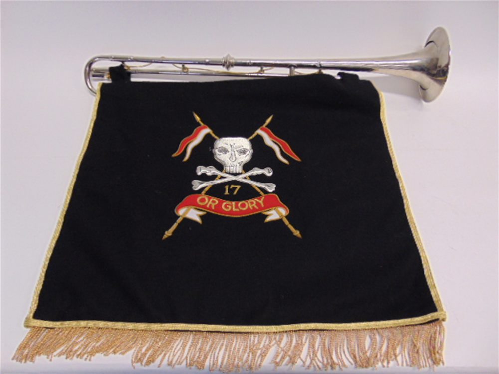 A SILVER PLATED MILITARY TRUMPET 76cm long (lacking mouth-piece), with a suspended embroidered
