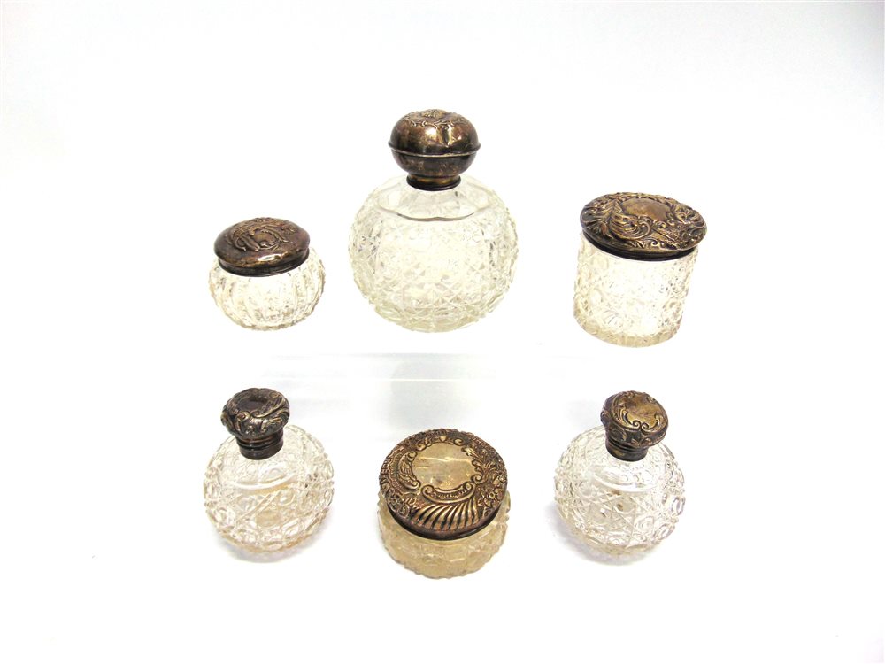 A PAIR OF SILVER MOUNTED GLASS LATE VICTORIAN SCENT BOTTLES Birmingham 1900, with stoppers; a larger