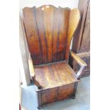 A 20TH CENTURY STAINED OAK AND ELM LAMBING CHAIR with shaped back and wing sides, solid seat over