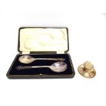 A CASED PAIR OF SILVER SERVING SPOONS H. Wilkinson Limited, Sheffield 1925, with pierced finials,