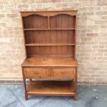 AN OAK ARTS AND CRAFTS STYLE DRESSER OF SMALL PROPORTIONS, fitted with two drawers over pot shelf,