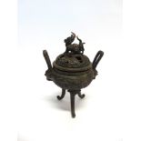 A BRONZE KORO AND COVER, with mask loop handles, the finial modelled as a mythical beast, raised