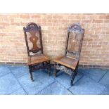 A PAIR OF CARVED OAK HALL CHAIRS, the vase shaped splats inlaid with hearts, 113cm high 47cm wide