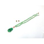 A UNIFORM JADE BEAD AND PENDANT NECKLACE the fifty nine beads of approximately 8-8.5mm, with two