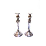 A PAIR OF TRANSITIONAL PLATED CANDLESTICKS the circular base with gadrooned band, to a knopped