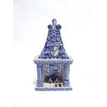 A DELFT MODEL FIREPLACE decorated with armorial shields and foliate enamels, 38cm high