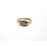 A THREE STONE DIAMOND CROSSOVER RING stamped 'Plat 18ct', the graduated single cut illusion set,