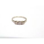 A THREE STONE DIAMOND RING stamped 'Plat', the graduated brilliant cuts totalling approximately 0.44