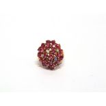 A RUBY AND OPAL CLUSTER RING indistinctly marked, the seven opals randomly set amongst the rubies,