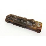 A CHINESE JADE CEREMONIAL SWORD HILT with carved decoration of pair of creatures, 13cm long