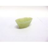 A SMALL CARVED JADE OVAL BOWL supported on four scroll feet, possibly a brush washer, 8cm wide