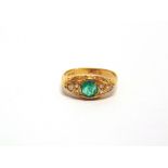 A 14 CARAT GOLD DIAMOND AND EMERALD RING the round cut stone flanked by a trio of brilliants to each