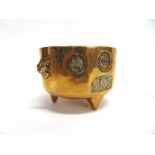 A CHINESE BRASS BOWL decorated with seals and pair of lion masks, on three prong feet, square seal