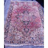 A LARGE RED GROUND HAND WOVEN CARPET with central medallion and foliate spandrels with a