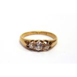 A LATE VICTORIAN THREE STONE DIAMOND 18 CARAT GOLD RING date letter erased, the graduated old