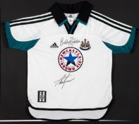 A white Newcastle United replica away jersey signed by Sir Bobby Robson and Alan Shearer,