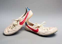 A pair of 1980s Sebastian Coe Nike running spikes, white with blue 'swoosh',