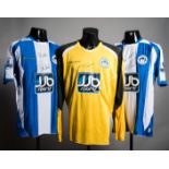 Three signed Wigan Athletic player jerseys, a Kevin Kilbane blue & white striped No.