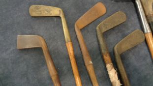 Eight hickory-shafted golf clubs, including two scared-neck persimmon head woods, a Wm.