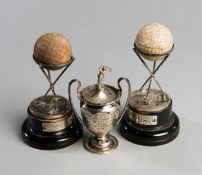 A pair of hallmarked silver Dunlop golf trophies, with appropriate balls and bases,