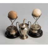 A pair of hallmarked silver Dunlop golf trophies, with appropriate balls and bases,