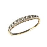 Yellow and white gold diamond set hinged bangle, tests 18 ct.