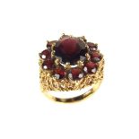 9 ct yellow gold garnet cocktail cluster ring. The central oval cut garnet weighing approx. 4.