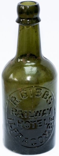 Beer bottle R.GIBBS RAILWAY HOTEL ILFRACOMBE. Green glass with moulded top lip, stands 7.5in tall.