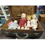 A leather suitcase including a quantity of celluloid and vinyl dolls and soft toys.
