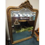 A reproduction gilt framed antique style mirror with bevelled arched plate.