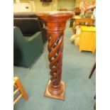 A reproduction mahogany effect torchere with open bine column.