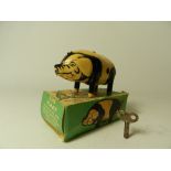 A boxed Wells Brimtoy tinplate toy pig with operating clockwork mechanism with key.