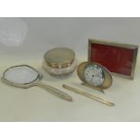 A silver mounted easel back timepiece together with a silver topped dressing table jar,