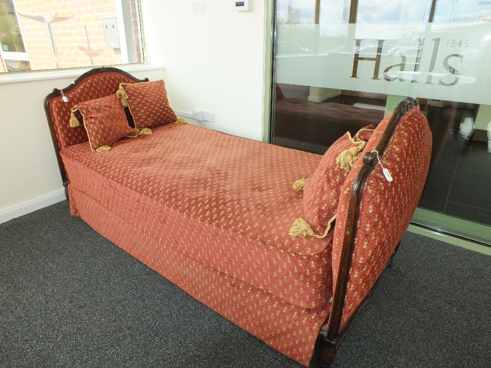 An Edwardian oak framed upholstered day bed
