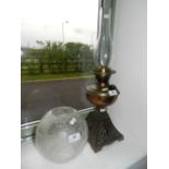 A 19th century double burner brass and cast iron oil lamp with acid-etched foliate shade and a