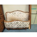 An early 20th century French style carved oak and upholstered bed frame with serpentine head board