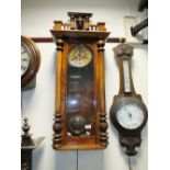 An oak cased Vienna type wall clock with architectural mask cresting
